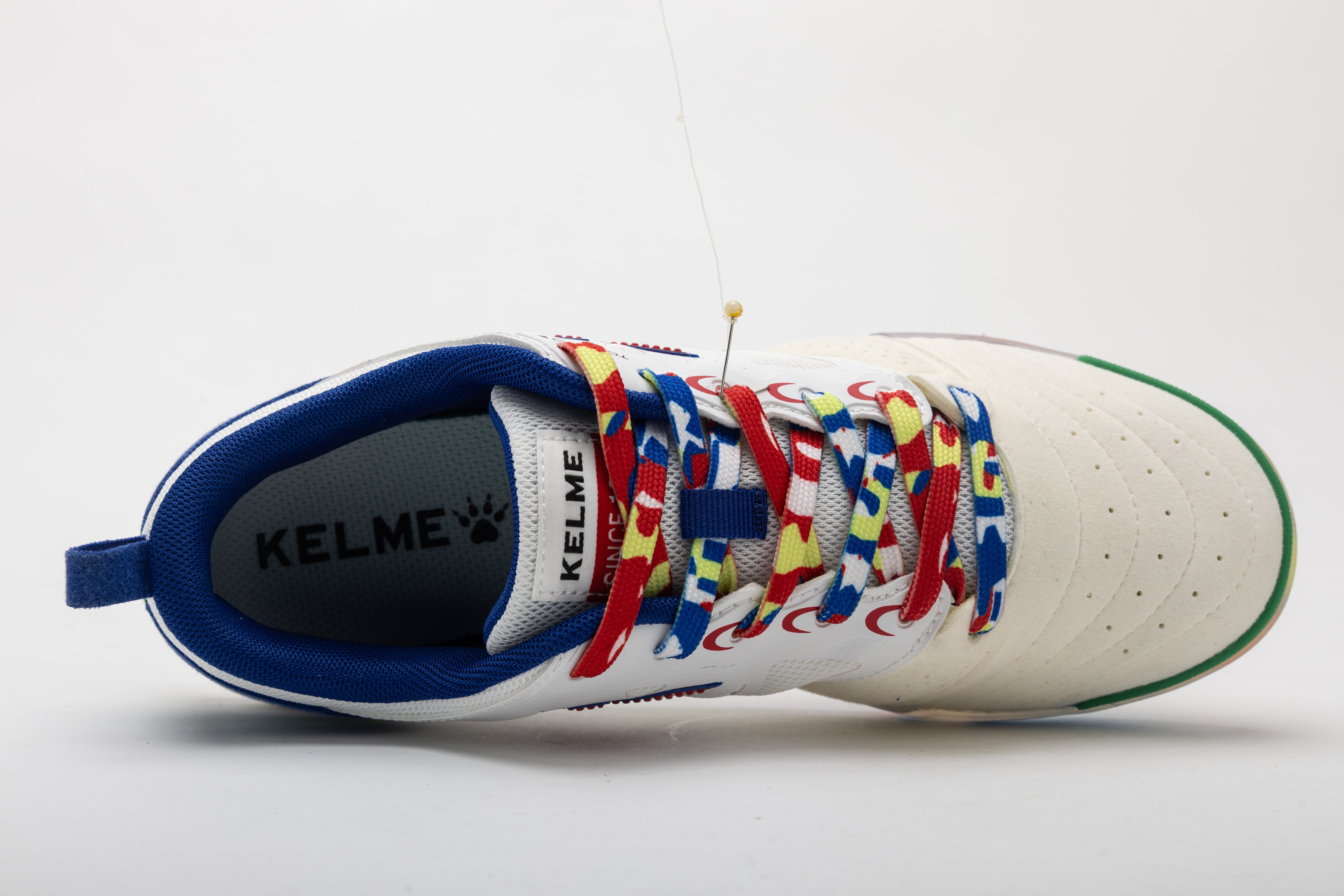 Men's futsal shoes by Kelme, side view with blue lining and patterned laces